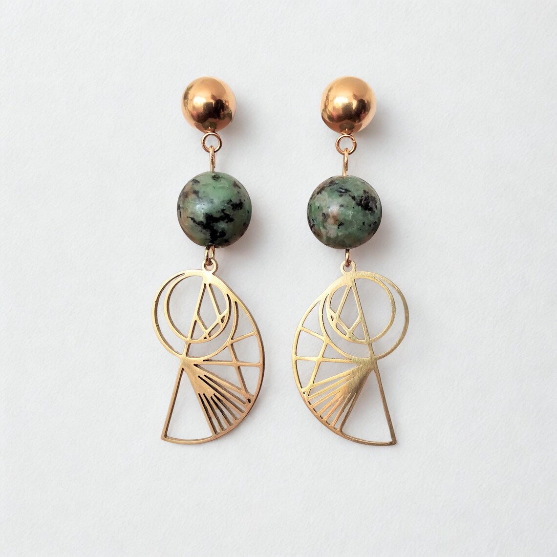 Bohemian gold-plated stainless steel drop earrings featuring round, green-speckled African Turquoise beads and geometric Golden Ratio shell charms on a white display