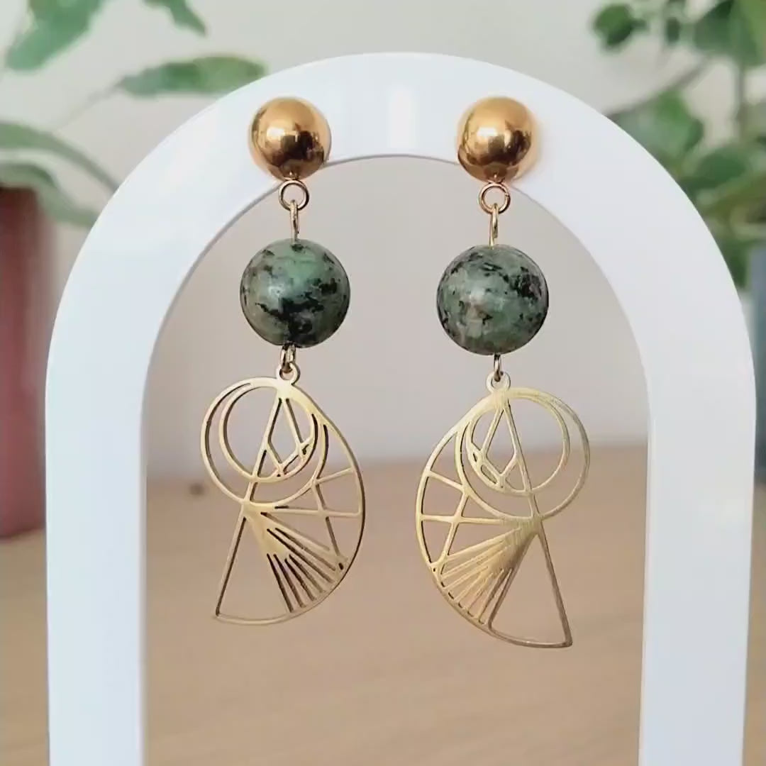 Bohemian gold-plated stainless steel drop earrings featuring round, green-speckled African Turquoise beads and geometric Golden Ratio shell charms on a white display